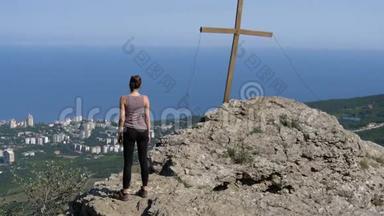 从后面的景色<strong>到站</strong>在岩石山顶上的女孩，看着远处。